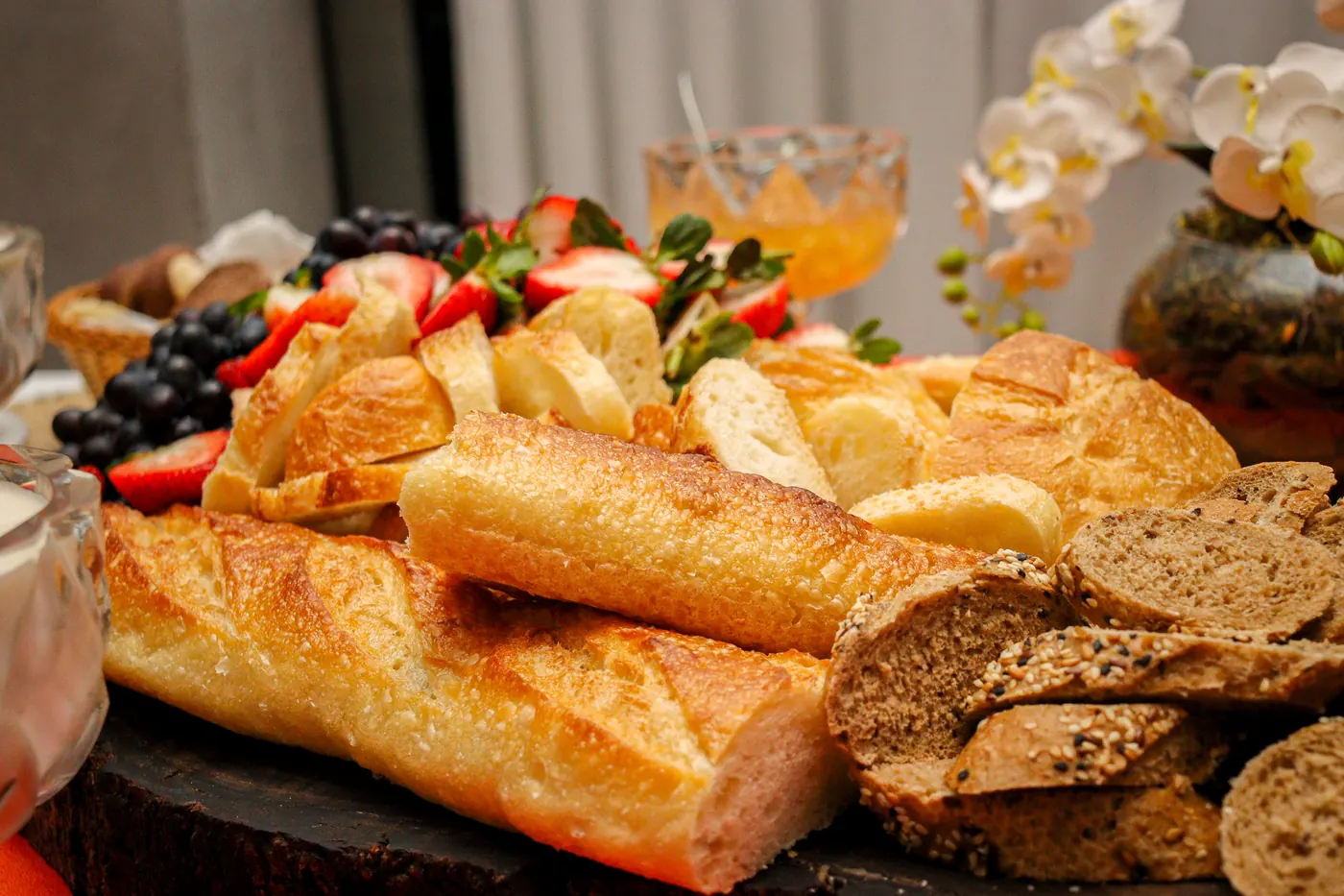 Mesa de pães artesanais com frutas e geleias