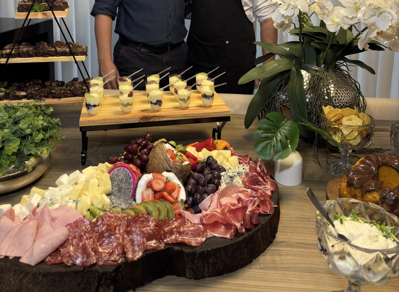 Mesa de frios farta com queijos, embutidos e frutas