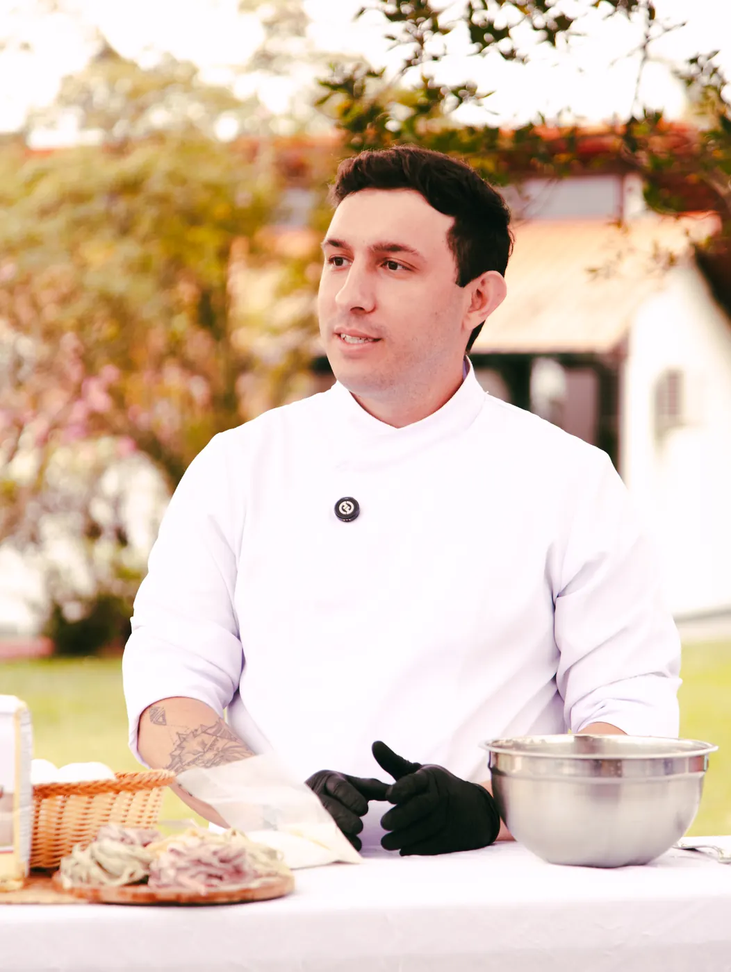 Chef Carlos Junior de dólmã branco em sua bancada