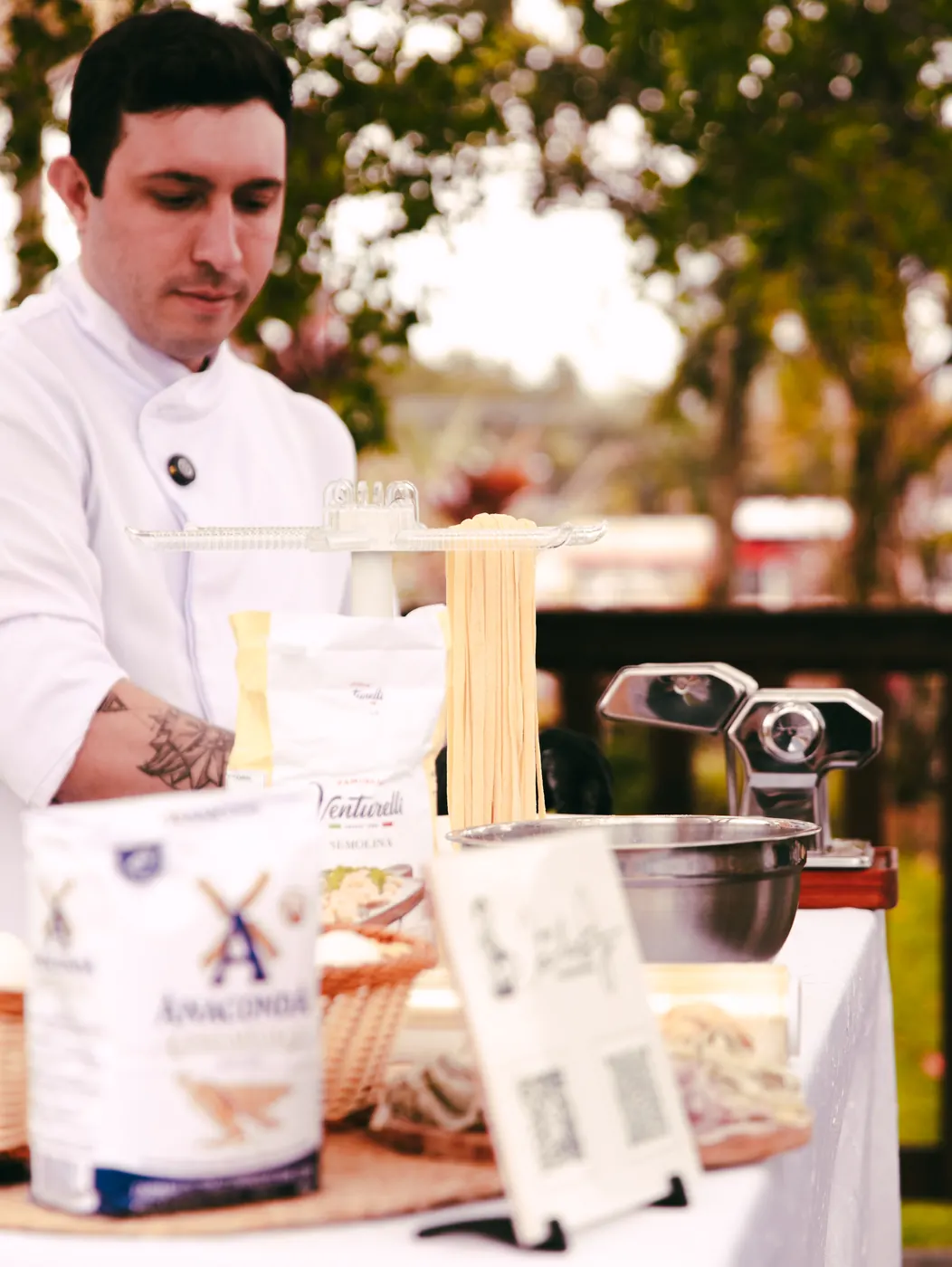 Chef Carlos Junior cortando massa fresca na máquina
